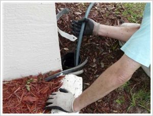 A professional plumbing relining a sewer pipe in a backyard